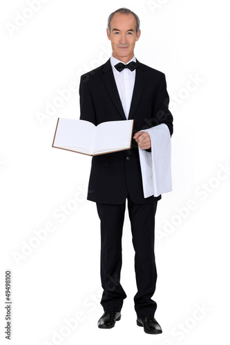 Photo: waiter is presenting a visitor book or a menu waiter is presenting a visitor book or a menu
