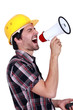 Male construction worker shouting into megaphone
