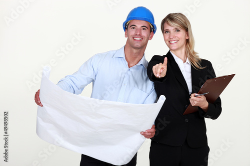 Photo: female architect and foreman holding plans female architect and foreman holding plans
