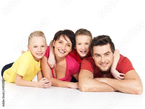 Photo: happy family with two children lying on white floor happy family with two children lying on white floor