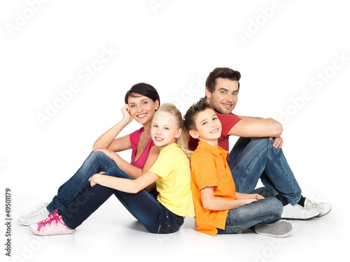 Photo: happy family with two children sitting on white floor happy family with two children sitting on white floor