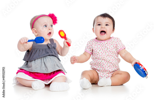 Photo: Funny babies girls with musical toys. Isolated on white backgro Funny babies girls with musical toys. Isolated on white backgro
