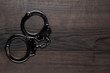 handcuffs on brown wooden table background