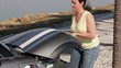 Woman with car trouble opens her hood 2