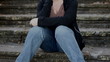 Sad woman sitting on steps tilt up