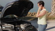 Woman with broken down car talking on her cellphone 2