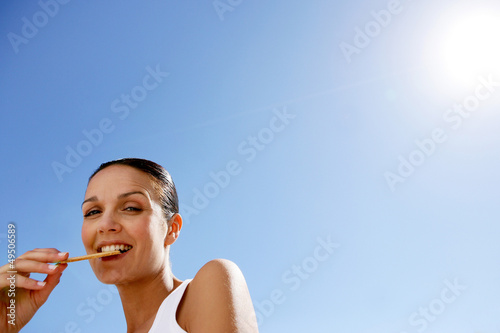 Photo: Brunette eating biscuit outdoors Brunette eating biscuit outdoors