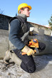Foto: Mason kneeling with lump hammer Mason kneeling with lump hammer
