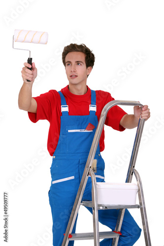 Photo: Man holding a paint roller Man holding a paint roller