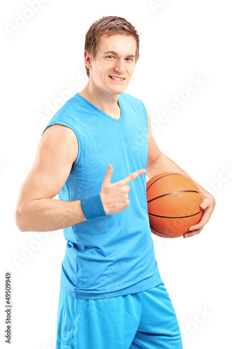 Photo: A smiling basketball player holding a ball and gesturing A smiling basketball player holding a ball and gesturing