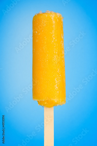Photo: Yellow fruit juice ice on blue background Yellow fruit juice ice on blue background