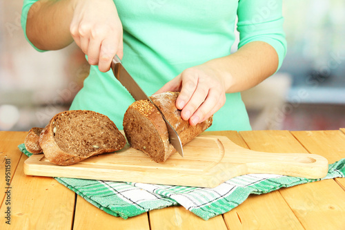 Photo: Woman slicing bread with sesame seeds Woman slicing bread with sesame seeds