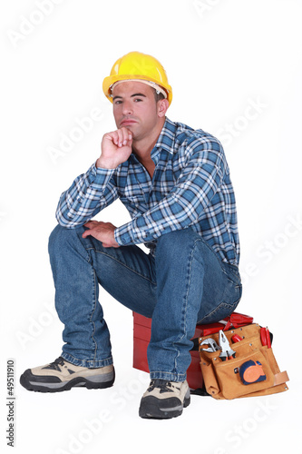 Photo: tradesman sitting on toolchest isolated on white tradesman sitting on toolchest isolated on white