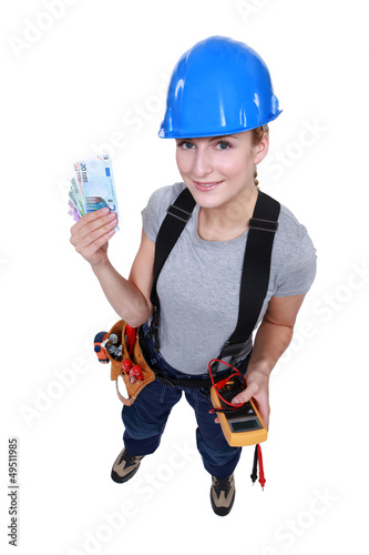 Photo: Female electrician holding wedge of cash Female electrician holding wedge of cash