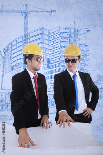 Photo: Architect and supervisor review blueprints Architect and supervisor review blueprints