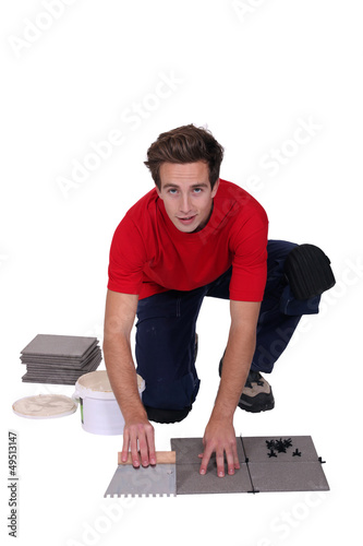 Photo: Man tiling the floor Man tiling the floor