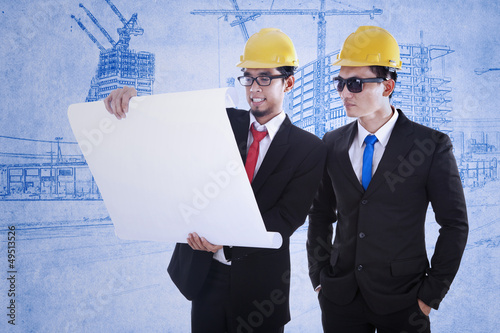 Photo: Two architects review plan Two architects review plan