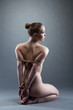 Pretty young woman with shibari sitting on floor
