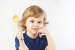 Little blonde boy holding a wooden spoon