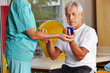 Senior mit Igelball bei Physiotherapie