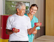 Senior hebt Hanteln bei Physiotherapie