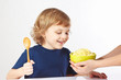 Little boy is going to eat a millet porridge
