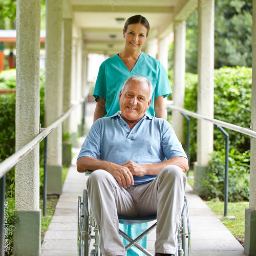 Photo: Krankenschwester schiebt Senior im Rollstuhl Krankenschwester schiebt Senior im Rollstuhl