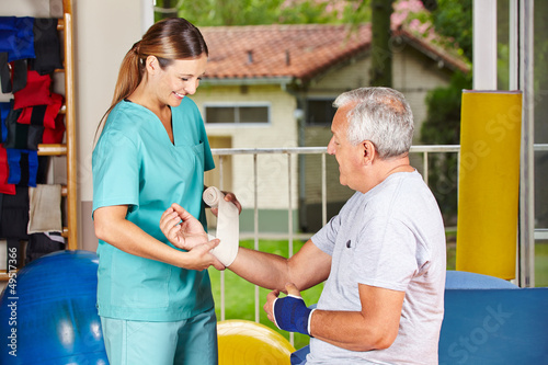 Photo: Krankenschwester bei Physiotherapie wechselt Verband Krankenschwester bei Physiotherapie wechselt Verband
