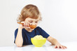 Little blonde boy eating a millet porridge