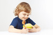 Beautiful child hugging a green bowl of millet cereal favorite