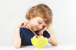 Little blonde child eating a millet porridge