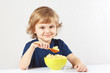 Little cute boy breakfast a millet porridge