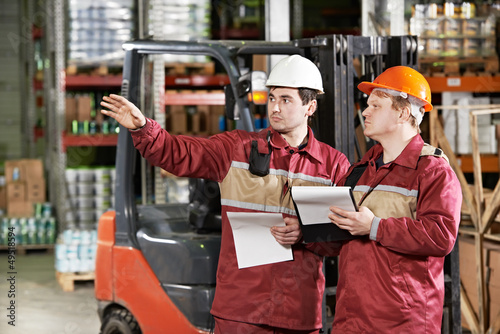 Photo: warehouse workers in front of forklift warehouse workers in front of forklift