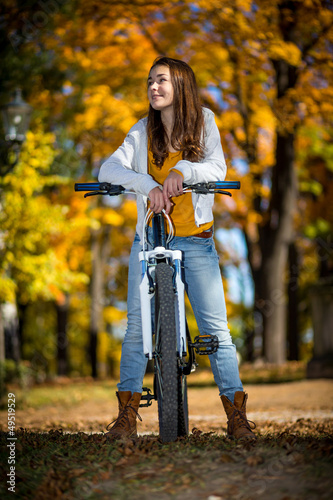 Photo: Girl biking in autumn park Girl biking in autumn park