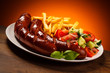 Grilled sausages, French fries and vegetables