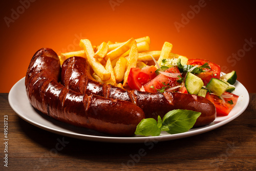 Photo: Grilled sausages, French fries and vegetables Grilled sausages, French fries and vegetables