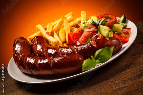 Photo: Grilled sausages, French fries and vegetables Grilled sausages, French fries and vegetables