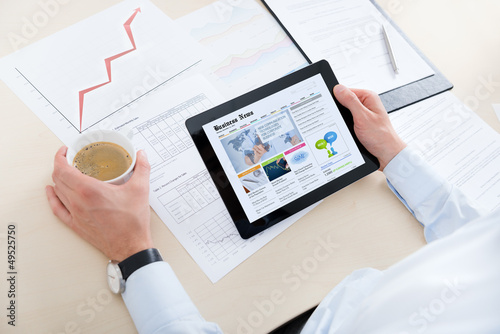Photo: Businessman reading latest news Businessman reading latest news
