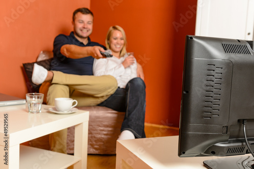 Photo: Happy couple watching tv evening changing channels Happy couple watching tv evening changing channels