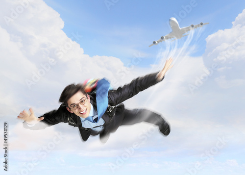 Photo: Young businessman flying with parachute on back Young businessman flying with parachute on back