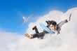 Young businessman flying with parachute on back