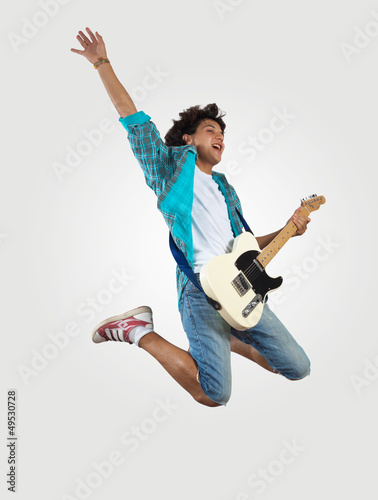 Photo: young man playing on electro guitar and jumping young man playing on electro guitar and jumping