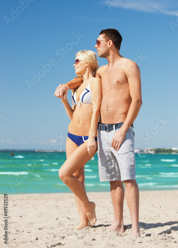 Photo: happy couple in sunglasses on the beach happy couple in sunglasses on the beach