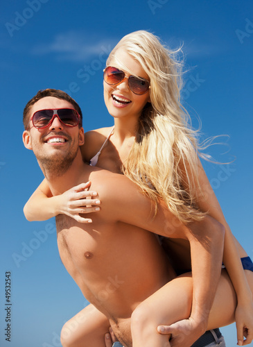Photo: happy couple in sunglasses on the beach happy couple in sunglasses on the beach
