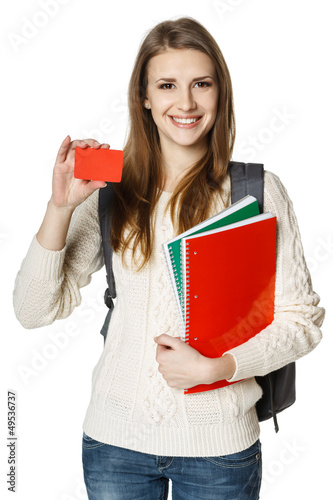 Photo: Woman student holding textbooks showing blank credit card Woman student holding textbooks showing blank credit card