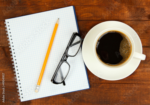 Photo: Cup of coffee on worktable covered with documents close up Cup of coffee on worktable covered with documents close up