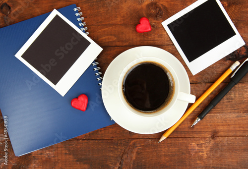 Photo: Cup of coffee on worktable covered with photo frames close up Cup of coffee on worktable covered with photo frames close up