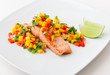 Salmon fillet with mango salsa on white plate.