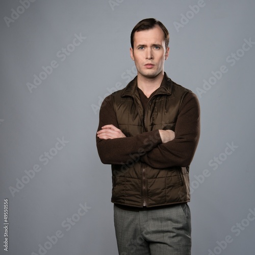 Photo: Man in vest isolated on grey background Man in vest isolated on grey background