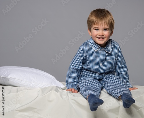 Photo: Little boy wearing blue pyjamas in bed Little boy wearing blue pyjamas in bed